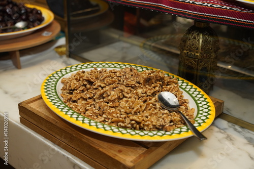 A beautifully presented platter of crunchy walnuts served on a vibrant plate, enticing guests with their rich flavor and nutritious appeal in a warm buffet setting.