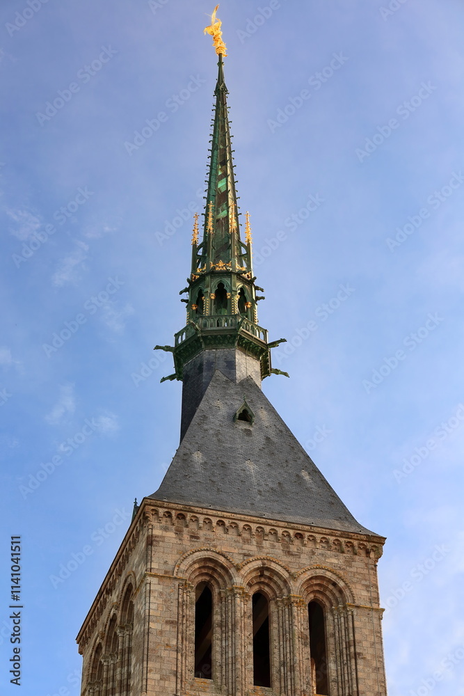 Obraz premium A gilded copper statue of Saint Michael tops the AD 1897, neo-Gothic spire erected over Le Mont-Saint-Michel Romanesque belfry. Normandy-France-109
