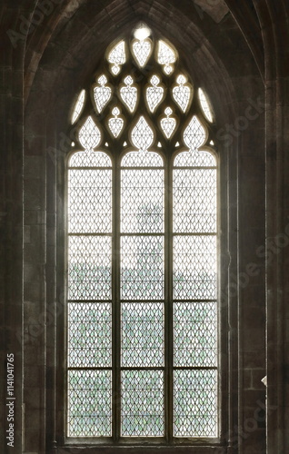 Multifoil arch topping a bar tracery window with stained-glass decoration on the ambulatory around Mont-Saint-Michel Church choir. Normandy-France-116 photo