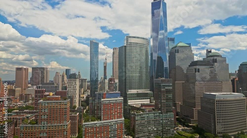 Manhattan and One World Trade Center in New York City, USA as seen from Weehawken New Jersey. Skyscrapers of Manhattan located near rippling water of New York bay against blue sky. NYC, USA.