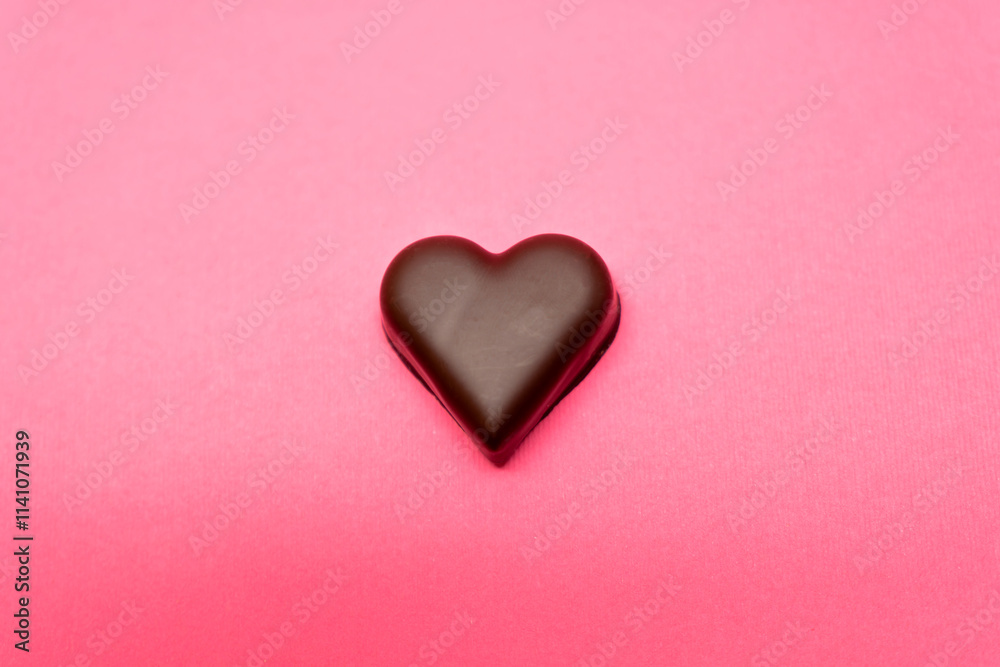 Chocolate heart set against a pink background. Love, romance, Valentine's Day themes. Abstract background. Chocolate heart set against a pink background. Love, romance, Valentine's Day themes. Abstract background.