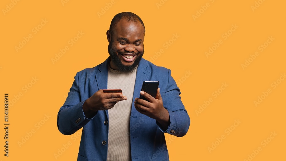 Happy man adding payment method on phone website, delighted to take advantage of promotions, studio background. Person thrilled to do internet shopping, typing credit card data on smartphone, camera A Happy man adding payment method on phone website, delighted to take advantage of promotions, studio background. Person thrilled to do internet shopping, typing credit card data on smartphone, camera A