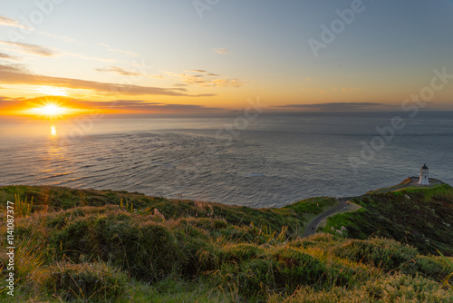 sunset over the sea at cape Reinga in New Zealand photo