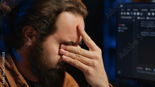 Foto Disappointed computer scientist puzzled after being unable to remove all bugs while coding on workstation desktop