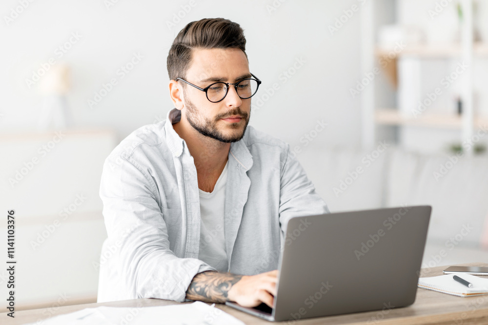 Concentrated self-entrepreneur working with laptop at home office, sitting at desk and using pc computer for remote work, copy space. Male freelancer enjoying distant job opportunities Concentrated self-entrepreneur working with laptop at home office, sitting at desk and using pc computer for remote work, copy space. Male freelancer enjoying distant job opportunities