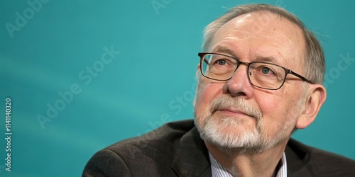 Senior Man in Glasses Against Teal Background