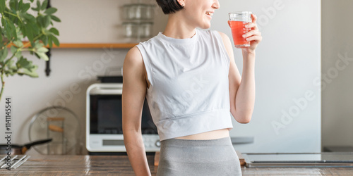 野菜ジュースを飲むスポーツウェア姿の若アジア人女性（便秘改善・むくみ予防・腸内環境）
