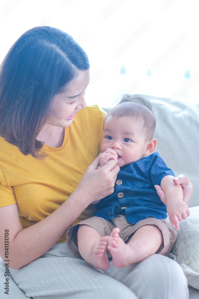 Asian woman with her son holding him by her hand. Happy baby boy was holding by his mother. Asian family with little boy at home enjoy tender family moment, motherhood. Asian woman with her son holding him by her hand. Happy baby boy was holding by his mother. Asian family with little boy at home enjoy tender family moment, motherhood.