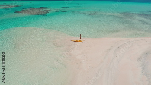 Woman enjoying a sunny day on a sandbank in a tropical paradise, surrounded by turquoise waters, clear skies, and fluffy clouds, evoking relaxation and freedom