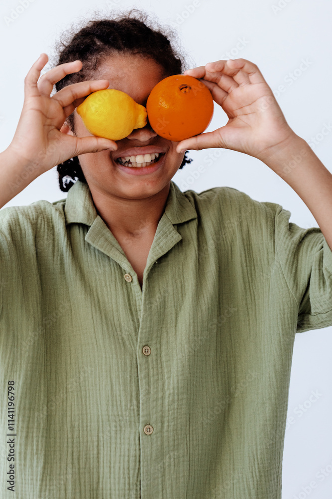 Playful woman holding oranges in front of her eyes with a smile Playful woman holding oranges in front of her eyes with a smile