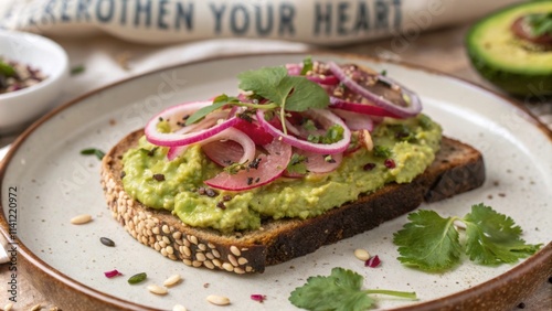 A closeup shot of an avocado toast masterpiece layered with vibrant green smashed avocado and topped with slices of pickled red onion and a sprinkle of cilantro for an added