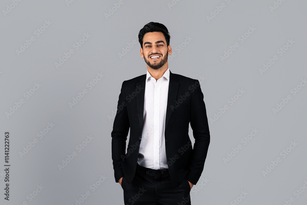 A middle eastern businessman stands confidently in a modern studio, wearing a black suit and smiling. The neutral backdrop emphasizes his professional look and positive demeanor. A middle eastern businessman stands confidently in a modern studio, wearing a black suit and smiling. The neutral backdrop emphasizes his professional look and positive demeanor.
