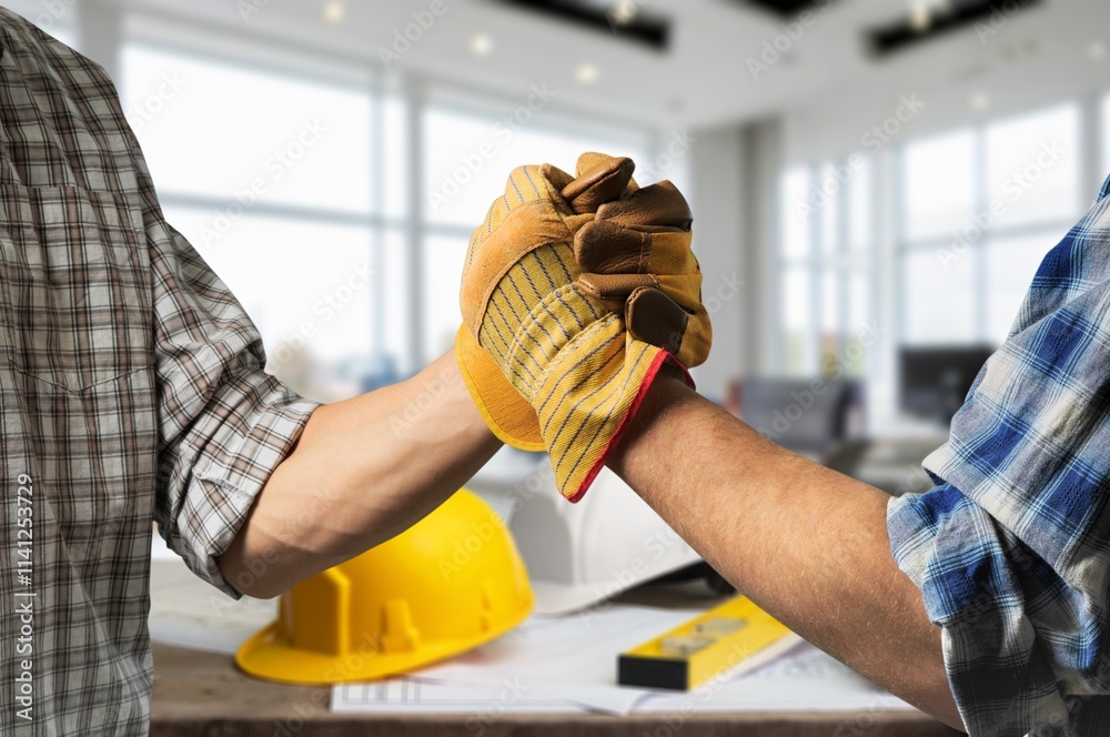 construction worker with contractor shaking hands in renovation site.