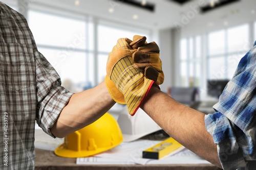 construction worker with contractor shaking hands in renovation site.