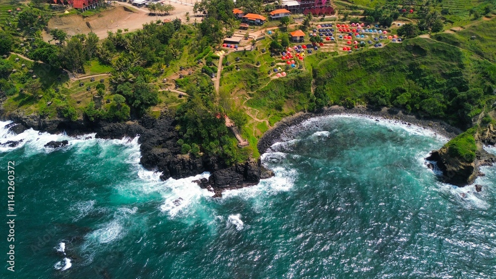 Aerial drone view of coastline with hills and trees, as well as view of coral cliffs and sea with waves from the ocean in Menganti Beach Kebumen Central Java Indonesia Aerial drone view of coastline with hills and trees, as well as view of coral cliffs and sea with waves from the ocean in Menganti Beach Kebumen Central Java Indonesia