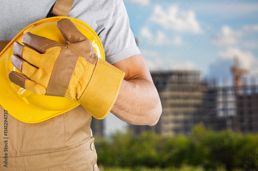 Fototapeta premium Safety workwear hold safety helmet at construction