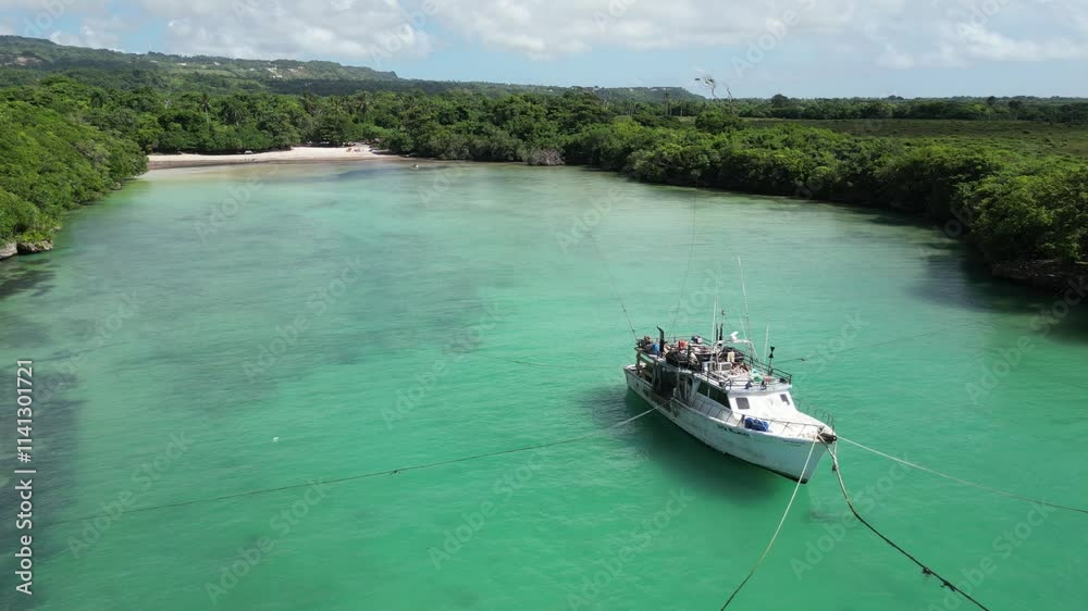 Aerial view of a boat anchoring in the shallow waters at picturesque Playa Diamante near Cabrera in the María Trinidad Sánchez province on the north coast of the Dominican Republic