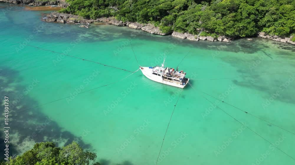 Aerial view of a boat anchoring in the shallow waters of picturesque Playa Diamante near Cabrera in the María Trinidad Sánchez province on the north coast of the Dominican Republic