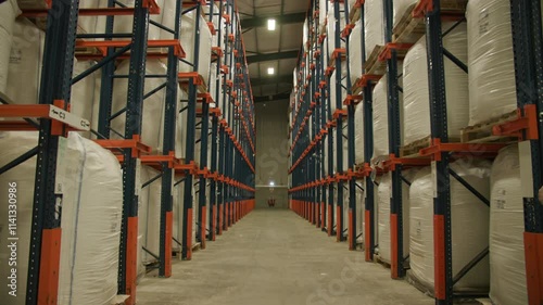 Large warehouse fully stocked shelves stretching to ceiling