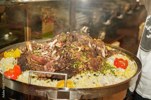 A glorious display of tender lamb resting atop a bed of fragrant rice, garnished with vibrant peppers and herbs, inviting diners to indulge in a hearty, flavorful feast
