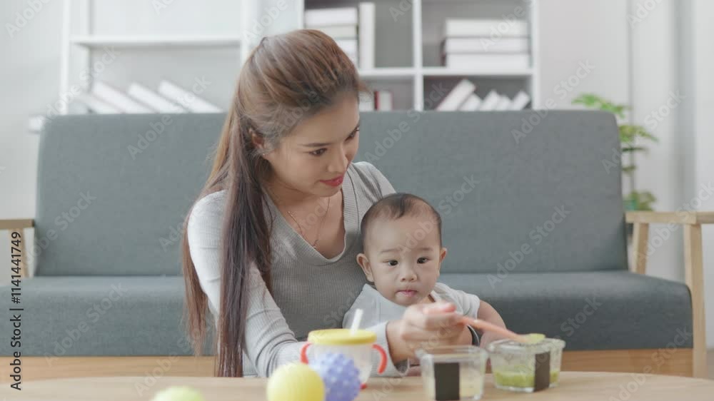 Mother remote working from home feeding food ans water and playing with her baby. Mother remote working from home feeding food ans water and playing with her baby.