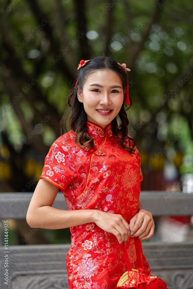Young beautiful Woman in Red Qipao Holding a Traditional Red gift Young beautiful Woman in Red Qipao Holding a Traditional Red gift