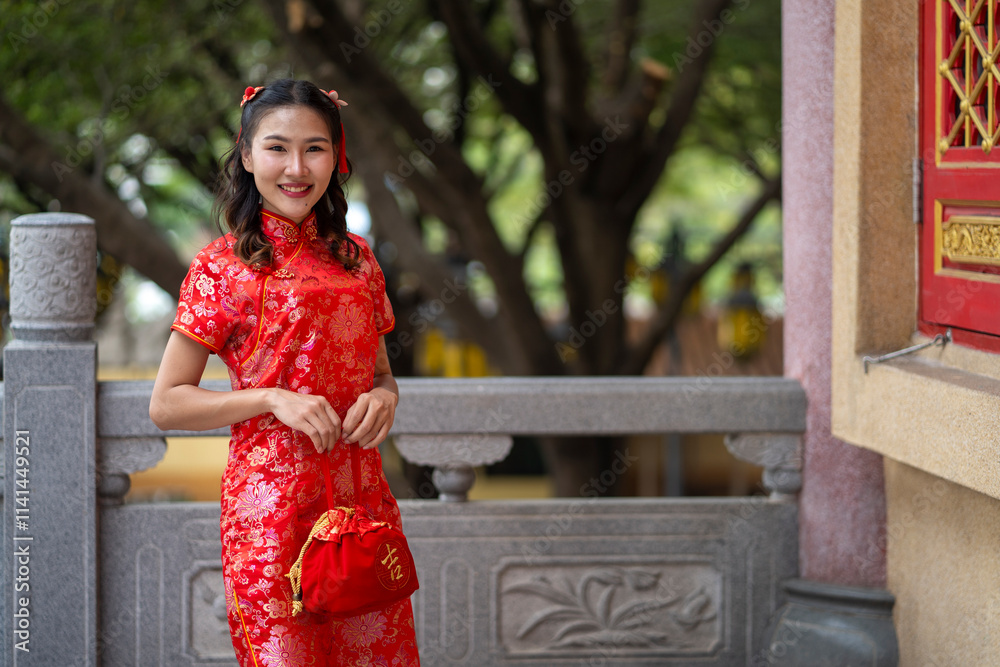 Young beautiful Woman in Red Qipao Holding a Traditional Red gift Young beautiful Woman in Red Qipao Holding a Traditional Red gift