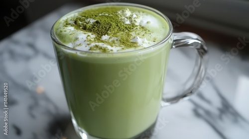 Matcha latte topped with whipped cream and matcha powder in a glass mug. Perfect for blogs, menus, or websites promoting cafes and healthy drinks.