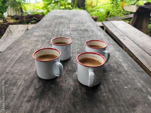 Cangkir kopi di atas meja kayu, latar belakang pemandangan toko tradisional yang alami dan buram. Cangkir kopi klasik di atas meja kayu. photo