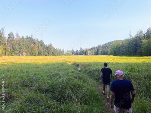 A father and son hiking through a field admiring a beautiful view of surrounding nature on Jedediah Island Marine Park photo