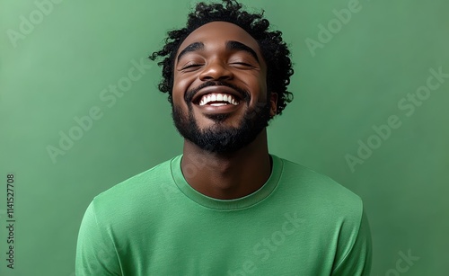 A man with a beard is smiling and wearing a t-shirt