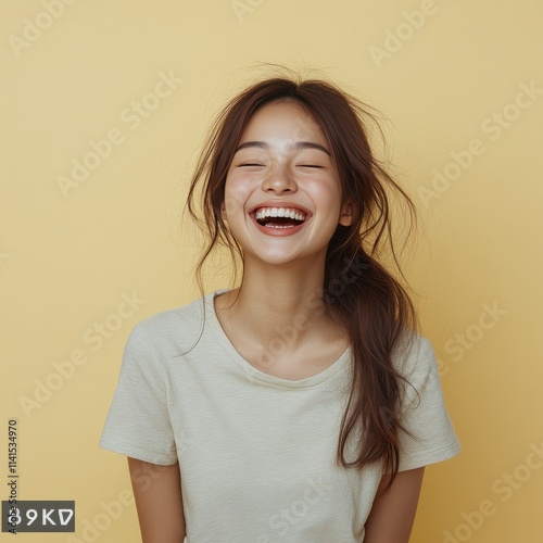 Asian woman smiling and wearing a t-shirt in studio color background