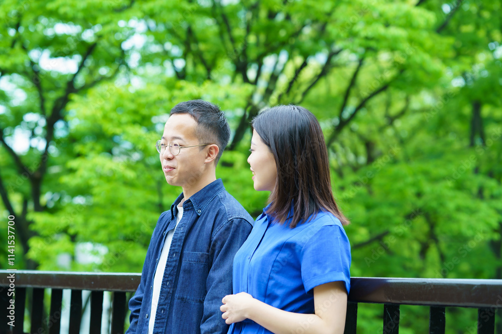 新緑の中で談笑する若いカップル 新緑の中で談笑する若いカップル