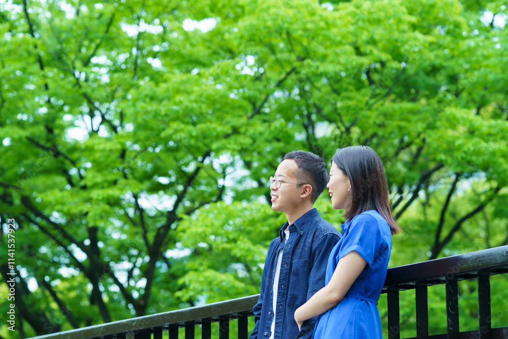 新緑の中で談笑する若いカップル