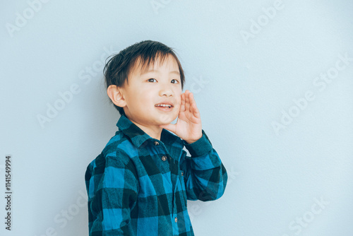 口に手を添えお話をする小さな男の子 photo