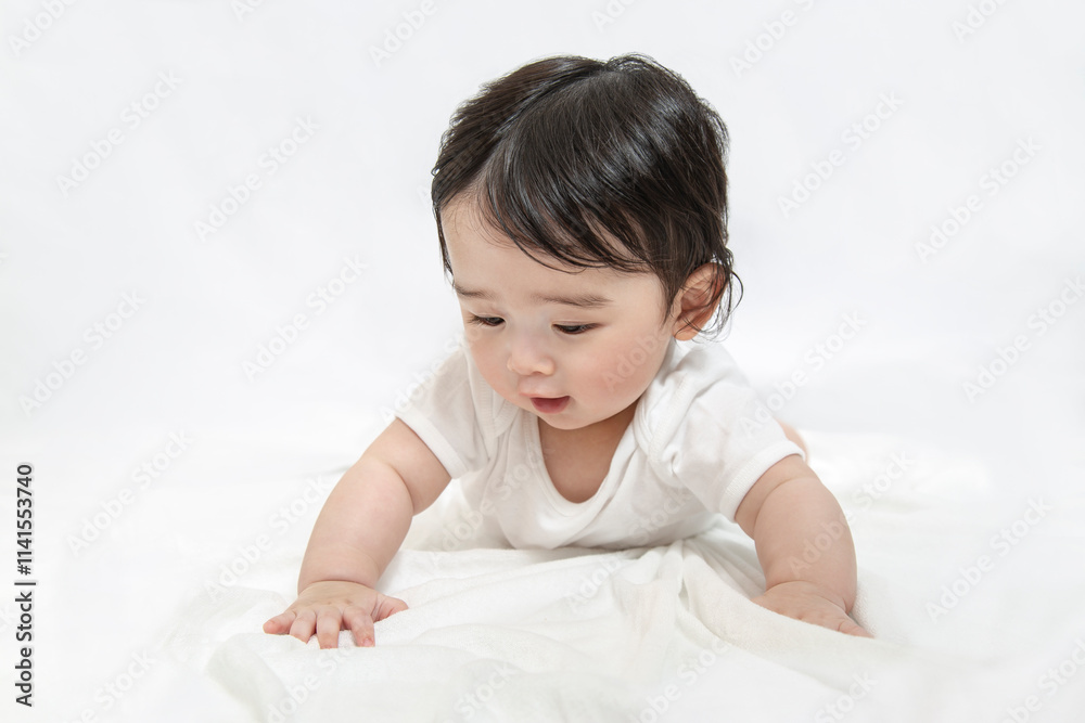 白シーツと白背景の前でハイハイする赤ちゃん 白シーツと白背景の前でハイハイする赤ちゃん
