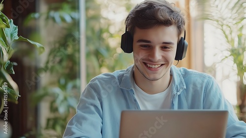 Portrait of a smiling young man in headphones using laptop at home. photo