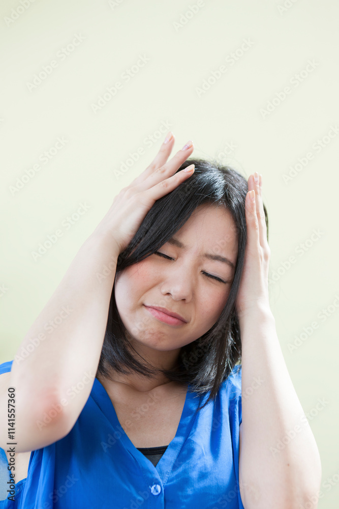 頭を抱える若い女性 頭を抱える若い女性