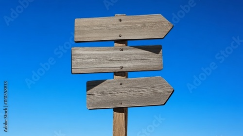 Empty wooden signpost against clear blue sky photo