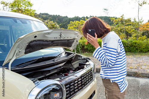 車の故障に困る女性