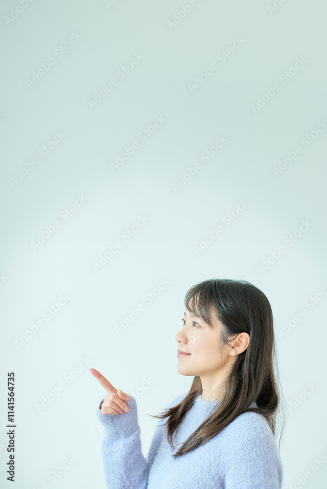 指さしのポーズをする若い女性 指さしのポーズをする若い女性