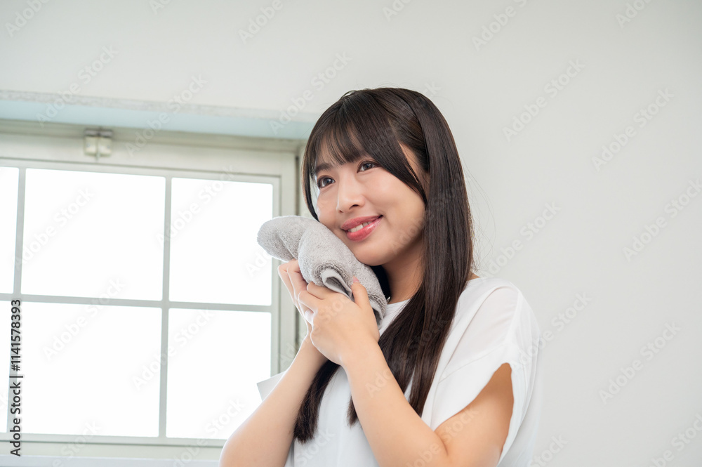 タオルで顔を拭く女性