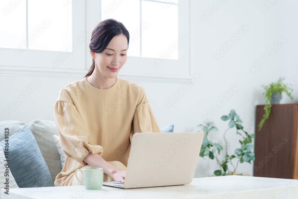家でパソコンを使って仕事する女性