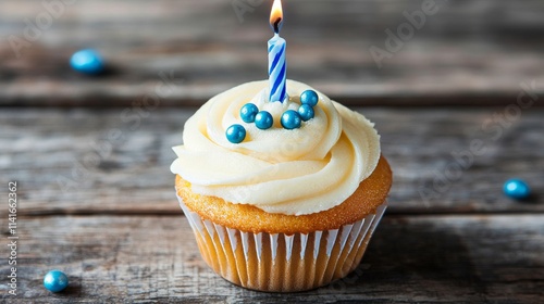 Delicious birthday cupcake with blue decorations and candle on a festive celebration table for anniversary or holiday celebrations photo