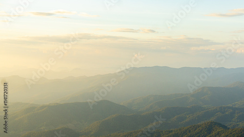Breathtaking mountain landscape with soft sunlight illuminating peaks and valleys, creating serene and tranquil atmosphere