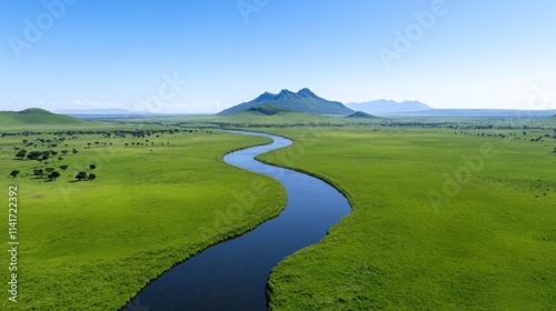 A winding river flows through a vast green landscape under clear skies.