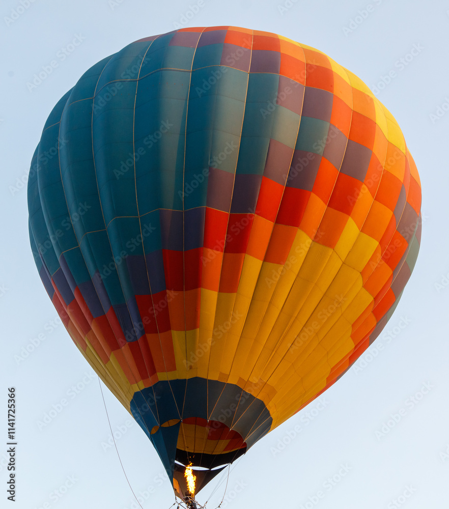 Obraz premium A hot air balloon with a blue and yellow pattern is floating in the sky
