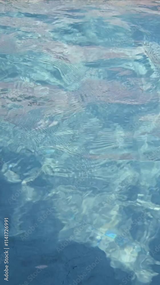 Vertical closeup view of crystal-clear water with calm and soft ripples on a sunny day Vertical closeup view of crystal-clear water with calm and soft ripples on a sunny day