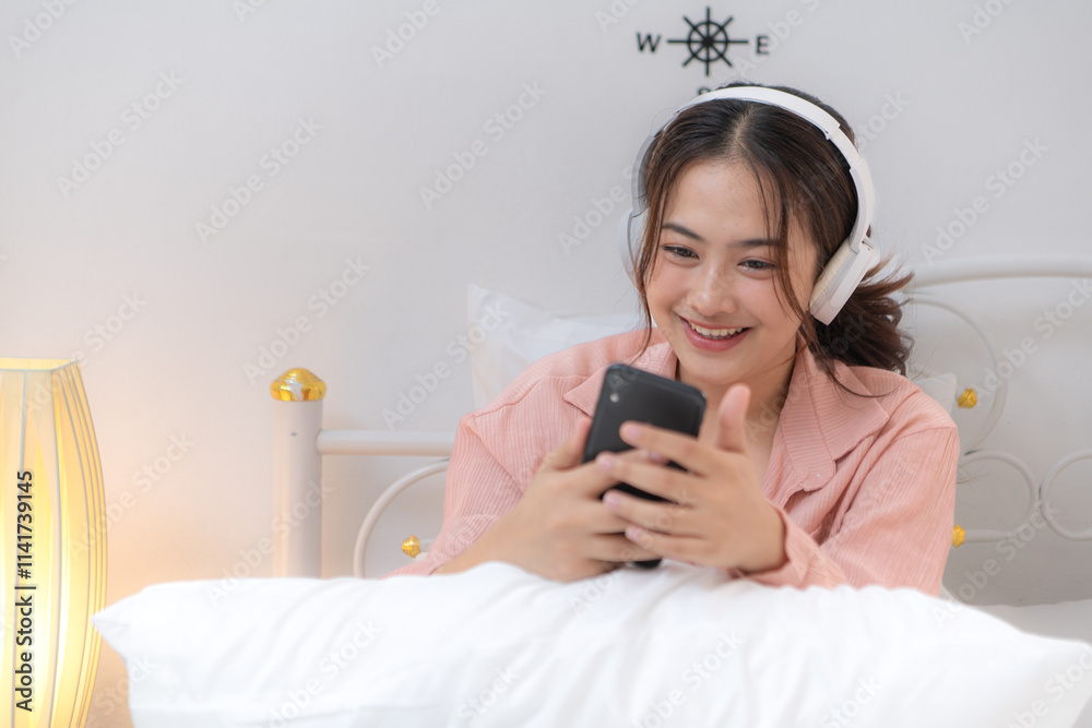 Asian young woman relaxing before bedtime on the bed in the bedroom Asian young woman relaxing before bedtime on the bed in the bedroom