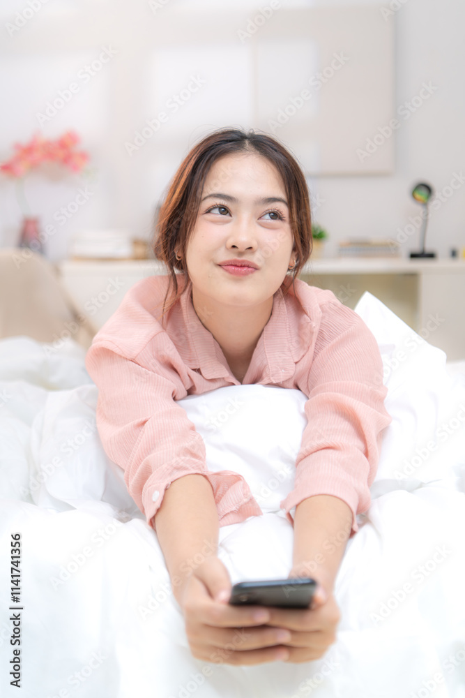 Asian young woman relaxing before bedtime on the bed in the bedroom Asian young woman relaxing before bedtime on the bed in the bedroom